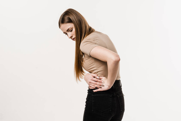 Nierinfectie pyelonefritis urineweginfectie. Meisje voelt rugpijn ruggengraat pijn als gevolg van UTI pyelonefritis ziekte - Foto, afbeelding