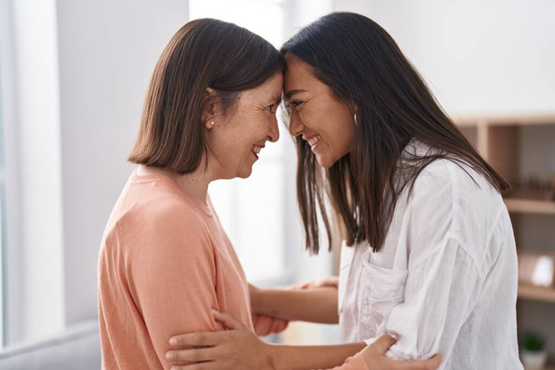 Two women mother and daughter smiling confident hugging each other at home - Foto, Imagen