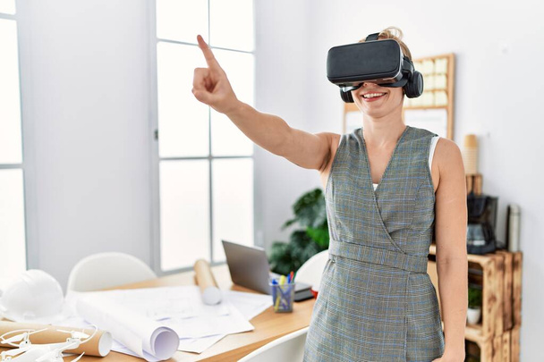 Young caucasian woman smiling confident using vr goggles working at architecture studio - Photo, Image