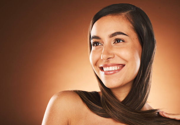 Face, beauty and hair with a model woman in studio on a brown background thinking about keratin treatment with mockup. Haircare, cosmetics and idea with a young female posing to promote hair care. - Photo, Image