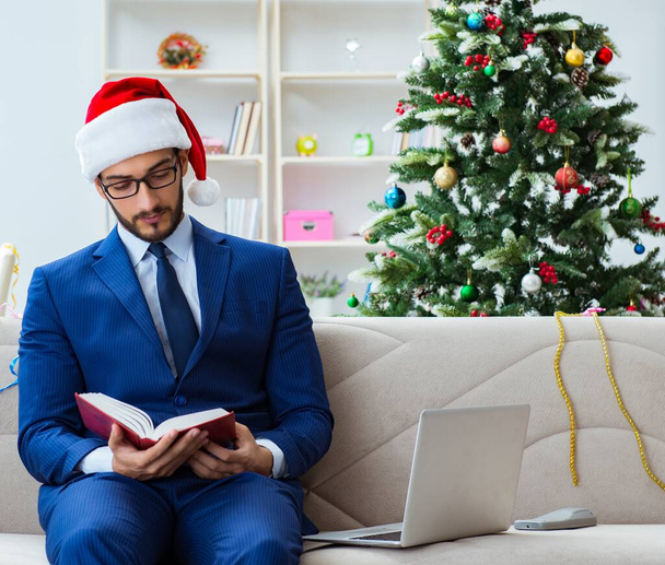 L'uomo d'affari che lavora a casa durante Natale - Foto, immagini
