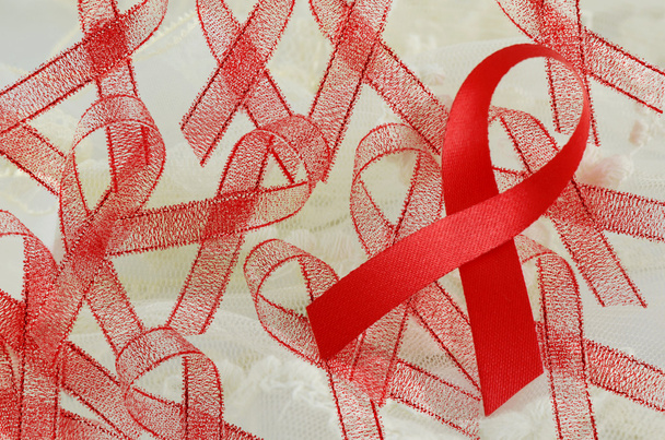 世界エイズ日赤いリボンに柔らかいクリーミーな背景に署名します。エイズ - Hiv キャンペーンに署名します。. - 写真・画像