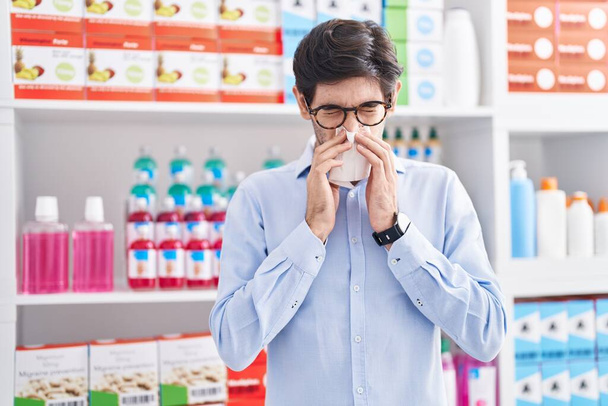 Fiatal spanyol férfi ügyfél használ nakpin a gyógyszertárban - Fotó, kép