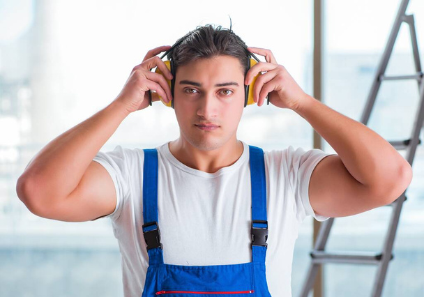 Pracovník se sluchátky potlačujícími hluk - Fotografie, Obrázek