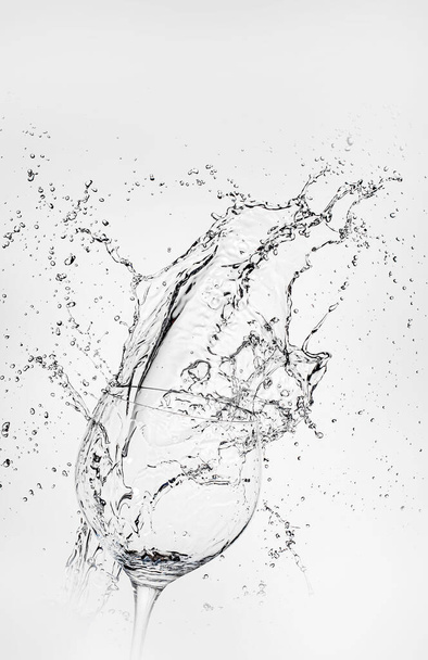big splash of water isolated on white background near by transparent glass. close up and good resolutions - Photo, Image