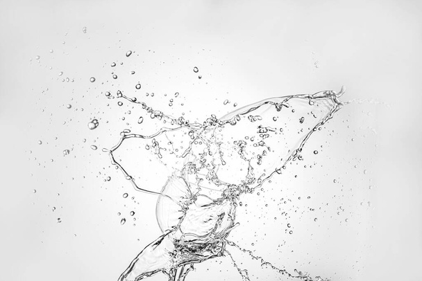 grande respingo de água isolada no fundo branco perto de vinagre transparente - Foto, Imagem