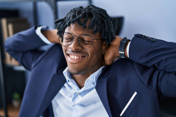 afroamericano uomo d'affari lavoratore rilassato con le mani sulla testa in ufficio - Foto, immagini