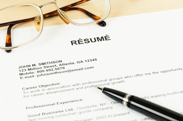 Resume with pen and glasses on table closeup - Photo, Image