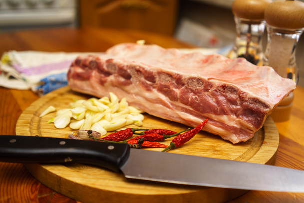 Свежие свиные ребрышки, мясо маринованное и приготовленное к жаркому с чесноком
 - Фото, изображение