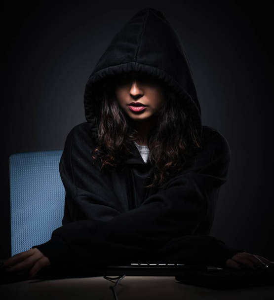 The female hacker hacking security firewall late in office - Photo, Image