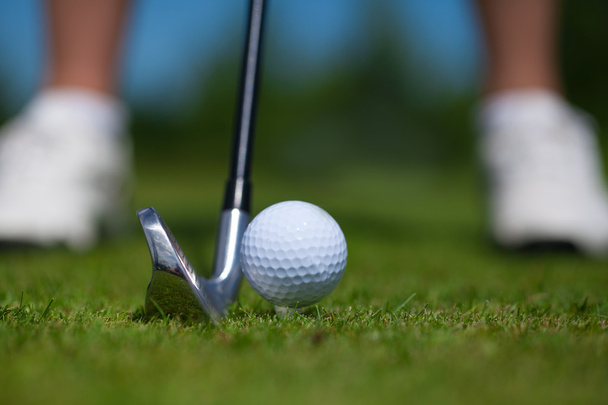 Golf ball op de tee en golf club op golfbaan - Foto, afbeelding