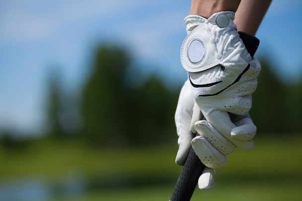 Golf pelaaja käsineet pitää rautaa tai putter
 - Valokuva, kuva