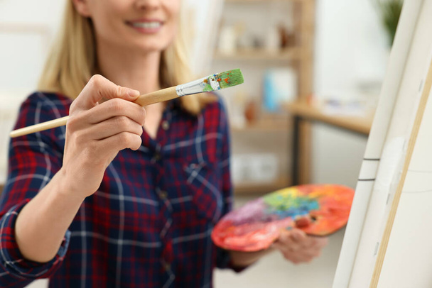 Woman painting on canvas in studio, selective focus. Creative hobby - Foto, Imagen