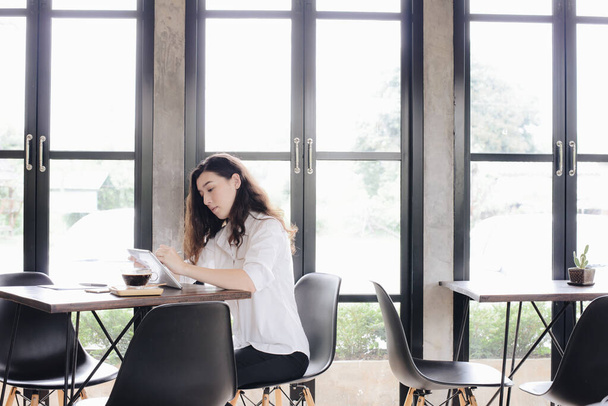 Retrato de una joven mujer de negocios de raza mixta tomar un descanso para tomar un café y esperar a sus amigos en la oficina moderna. - Foto, Imagen