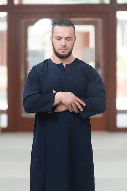 Young Muslim Man Making Traditional Prayer To God While Wearing A Traditional Cap Dishdasha - Zdjęcie, obraz