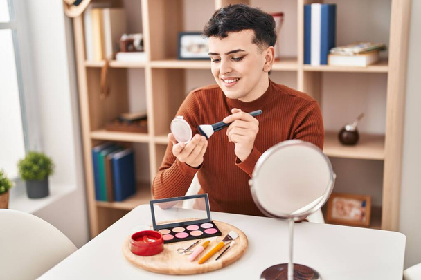 Young non binary man smiling confident applying makeup at home - Photo, Image