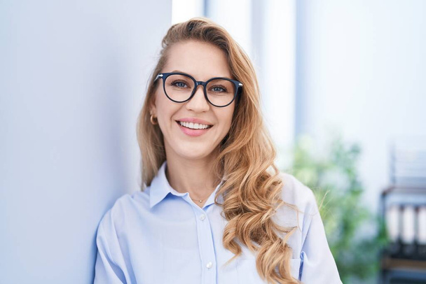 fiatal szőke nő üzleti dolgozó mosolygós magabiztos az irodában - Fotó, kép