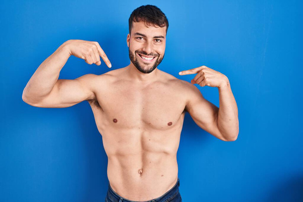 Handsome hispanic man standing shirtless looking confident with smile on face, pointing oneself with fingers proud and happy.  - Photo, Image