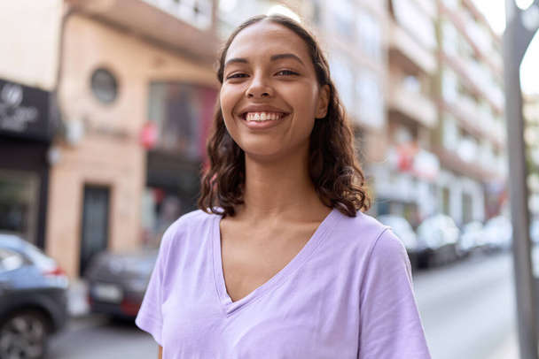 Молода афроамериканська жінка, яка впевнено посміхається на вулиці. - Фото, зображення
