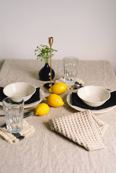 Vintage τραπέζι με λινά χαρτοπετσέτες και κίτρινα λεμόνια. Τραπέζι διακόσμησης. Κλείσε. Ζεστό ήρεμο γεύμα το πρωί στη λιακάδα. - Φωτογραφία, εικόνα