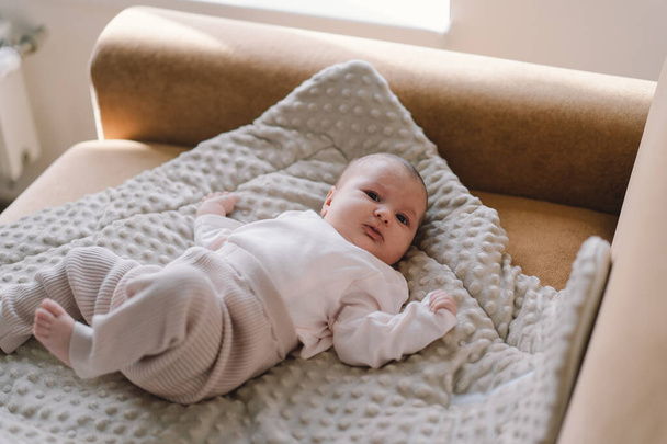 Portrait d'un bébé de 1 mois. Mignon nouveau-né couché sur un tapis en développement. Amour bébé. Nouveau-né et mère. - Photo, image