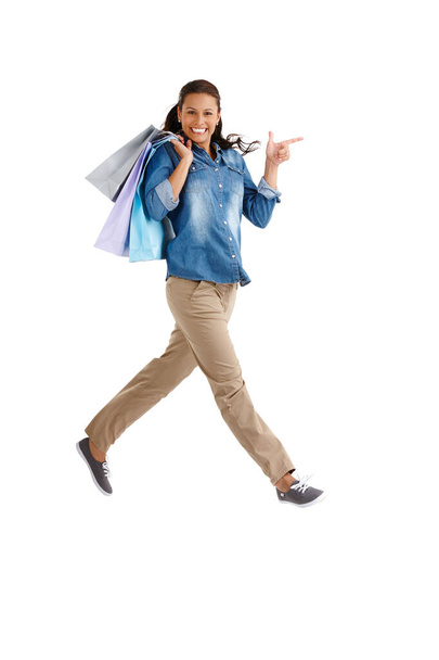 Next stop...the next shop. Studio portrait of an attractive young woman carrying shopping bags isolated on white - Photo, Image
