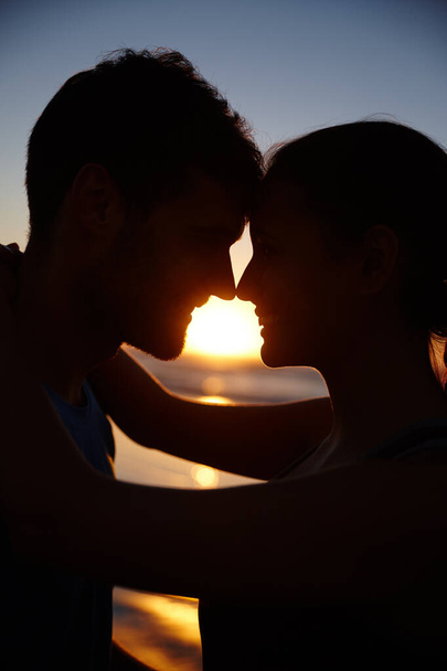 Start the day with romance. Closeup image of a romantic couple silhouetted against the sunrise - Fotografie, Obrázek