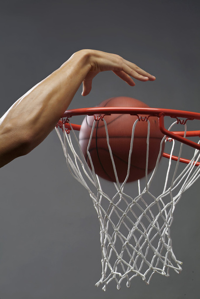 muž dunking basketbal skrze síť s jednou rukou - Fotografie, Obrázek