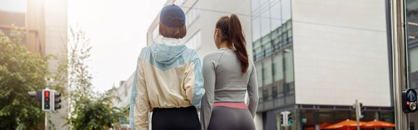 Two sportive young female friends walking city after morning running. Healthy lifestyle - Zdjęcie, obraz