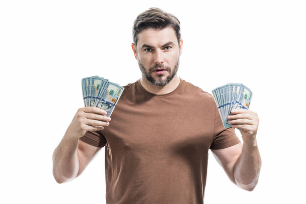 Good payment. Handsome business man holding money isolated over grey studio. Money in dollar banknotes. Pile of cash, finance, investment and money saving - Photo, Image