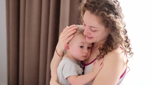 close-up portret van een moeder en haar zoon die slaapt in mama 's armen - Video