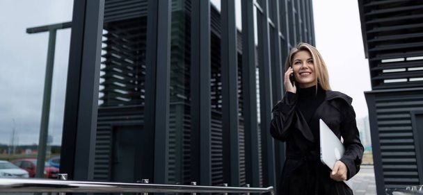 ampla foto horizontal de uma mulher de negócios confiante na frente de um prédio de escritórios. - Foto, Imagem