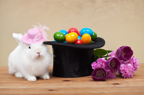 Χαριτωμένο λαγουδάκι του Πάσχα με ανοιξιάτικα λουλούδια και πολύχρωμα αυγά - Φωτογραφία, εικόνα
