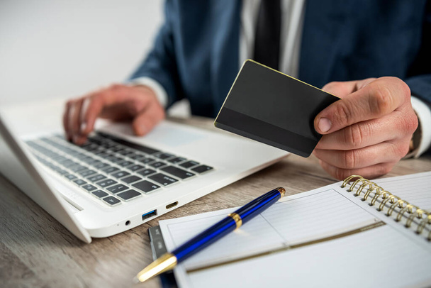 Homme en costume shopping en ligne et payer par carte de crédit à l'aide d'un ordinateur portable à la maison ou au bureau - Photo, image