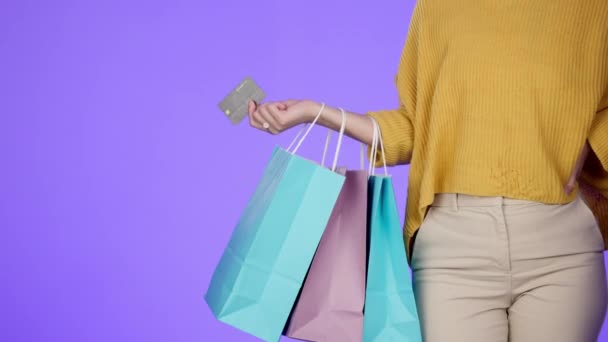 Einkaufstasche, Finanzen oder Hand mit Kreditkarte im Studio von Produktverkäufen isoliert auf violettem Hintergrund. Zoom, Kunde oder Mädchen kaufen mit Taschen voller Kleidung oder Mode im Einzelhandel Rabattaktion. - Filmmaterial, Video