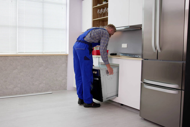 Oven Repair Technician. Appliance Maintenance Service And Installation - Foto, afbeelding