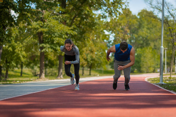 Two friends doing short sprints together at the park - Fotoğraf, Görsel
