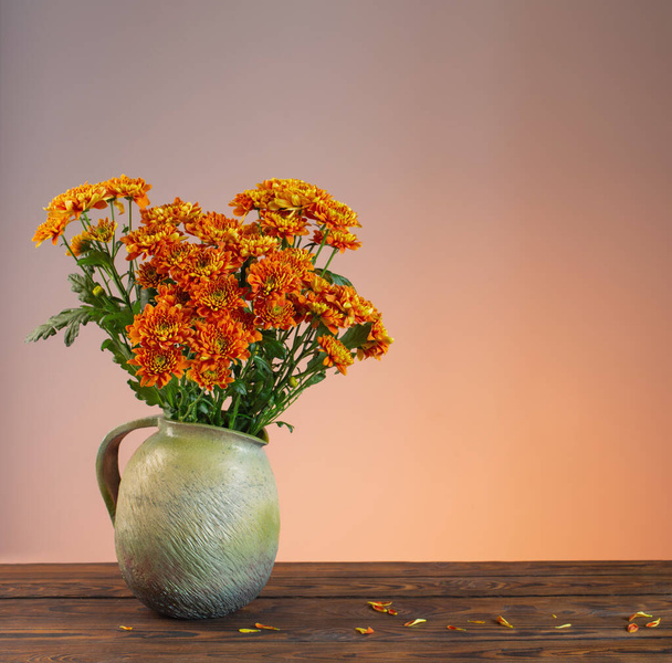 orange chrysanthemums in  vase on wooden background - Fotografie, Obrázek