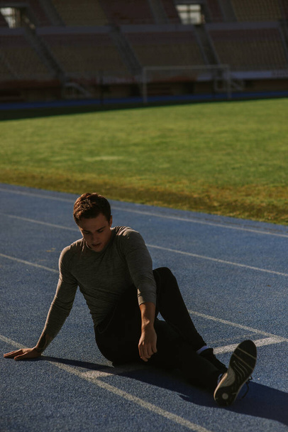 Un hombre guapo está estirando su cuerpo antes de entrenar. - Foto, Imagen