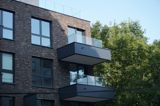 Warsaw, Poland, June 26th 2022 - Modern residential building with balconies and dark brick facade. Real estate and housing issues concept. - Photo, Image