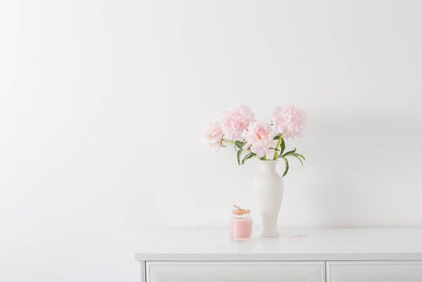 pink peonies in ceramic white vase in white interior - Photo, image