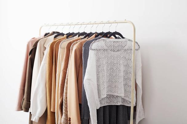 female autumn clothes on hangers  in  white room - Foto, imagen