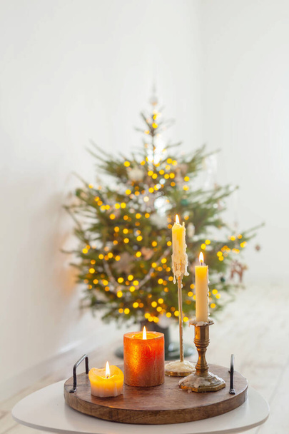 burning candles on table on background christmas tree at home - Foto, Bild