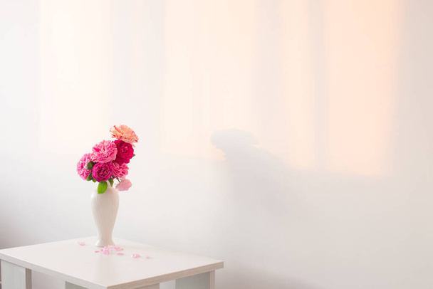 pink roses in white vase on table  on background white wall - Foto, Imagen