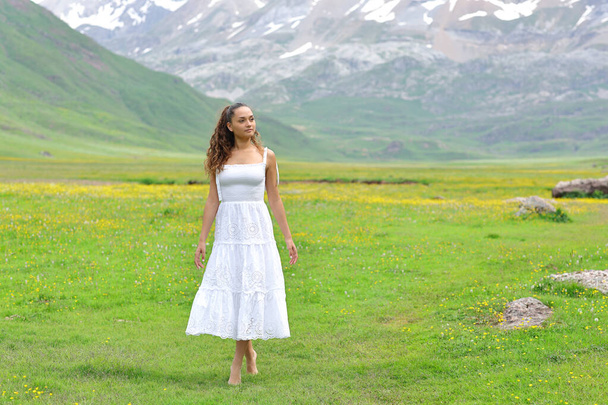 Front view of a woman in white dress walking in the mountain - Foto, imagen