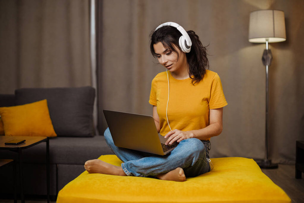 Feliz indio o árabe joven mujer independiente en el sofá y el uso de la computadora portátil. Trabajo remoto - Foto, Imagen