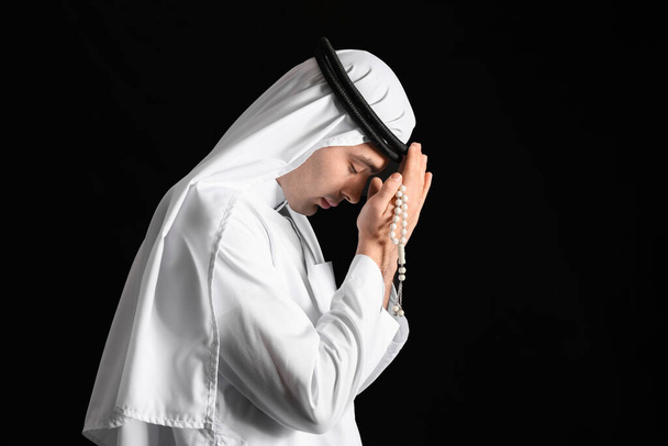 Praying Muslim man on dark background - Foto, afbeelding