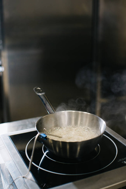 Cooking caramel in a saucepan on inductive cooking surfaces. - Foto, imagen