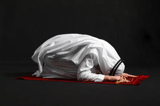 Praying Muslim man on dark background - Foto, imagen
