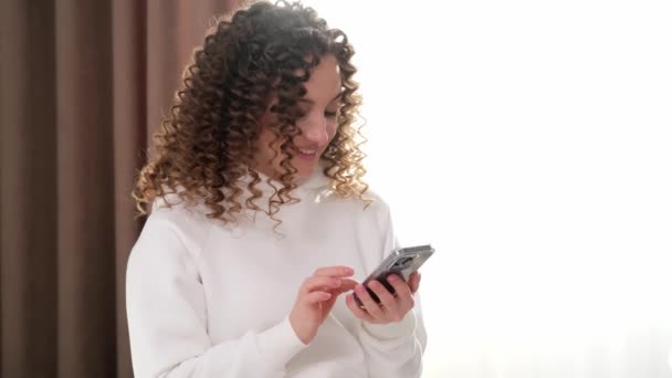 クローズアップビジネス女性は,自宅のオフィスで携帯電話にメッセージを入力します. 若い女の子が遅い動きで携帯電話にテキストを送っている. - 映像、動画